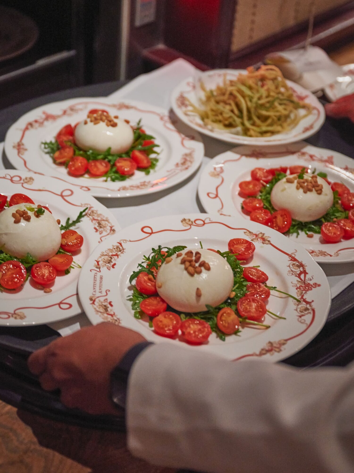Burrata with cherry tomatoes, rocket and toasted pine nuts being served at Cantinetta Antinori London
